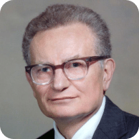 An old man with glasses and silver hair posing for an official photo.