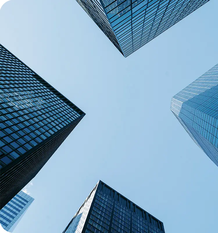 A picture of corporate buildings photographed from below with clear blue skies.