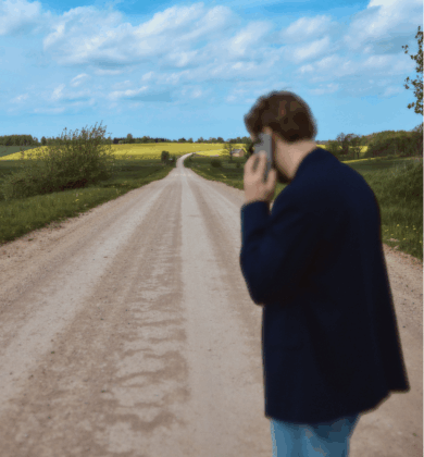Man on a country road, talking on the phone